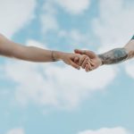 Imagen de una pareja sana y feliz tomada de la mano y riéndose juntos, representando una relación de pareja sana y feliz.