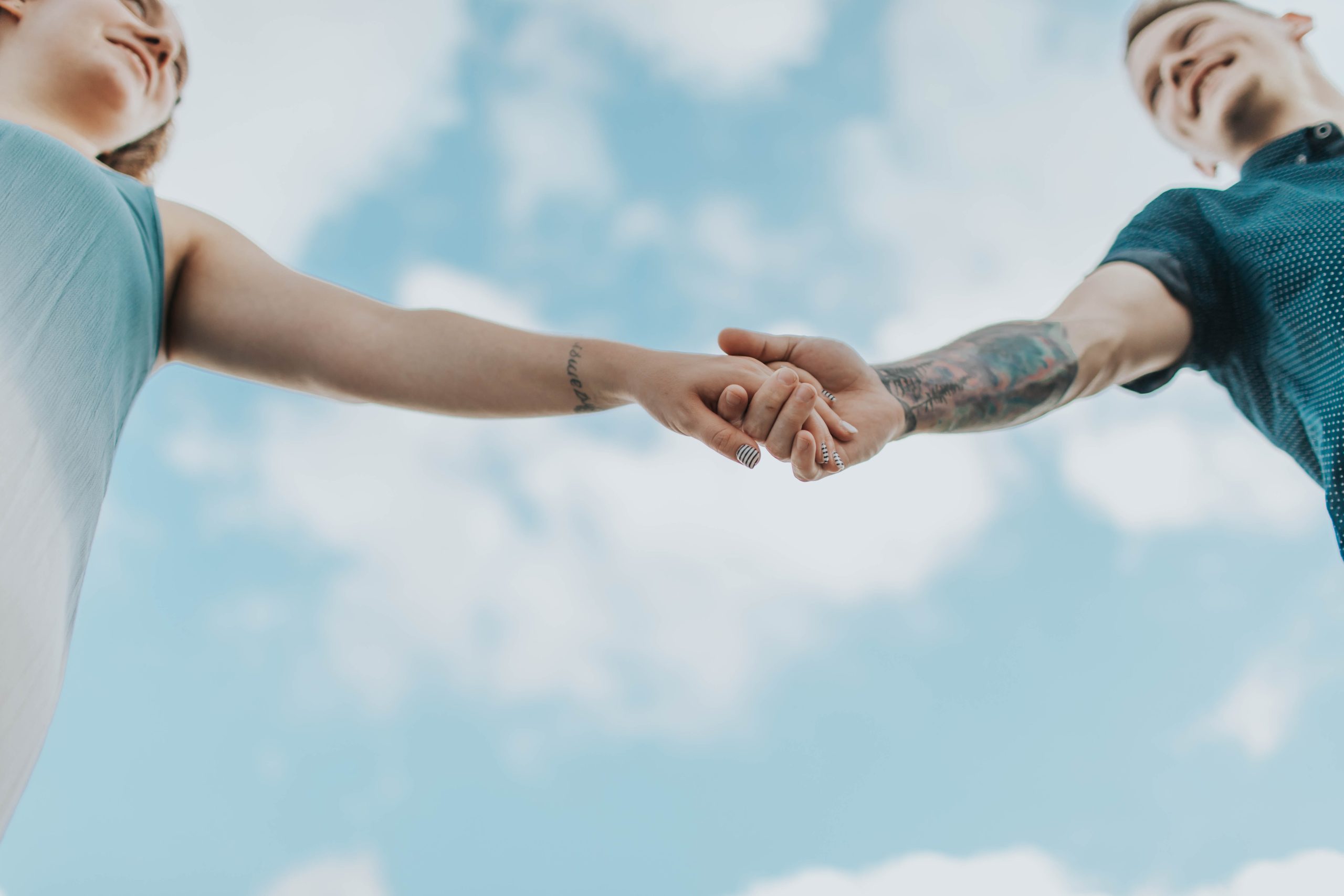 Imagen de una pareja sana y feliz tomada de la mano y riéndose juntos, representando una relación de pareja sana y feliz.
