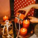 Vela iluminada junto a un regalo, simbolizando la conexión emocional y el bienestar en la psicología positiva durante las festividades.
