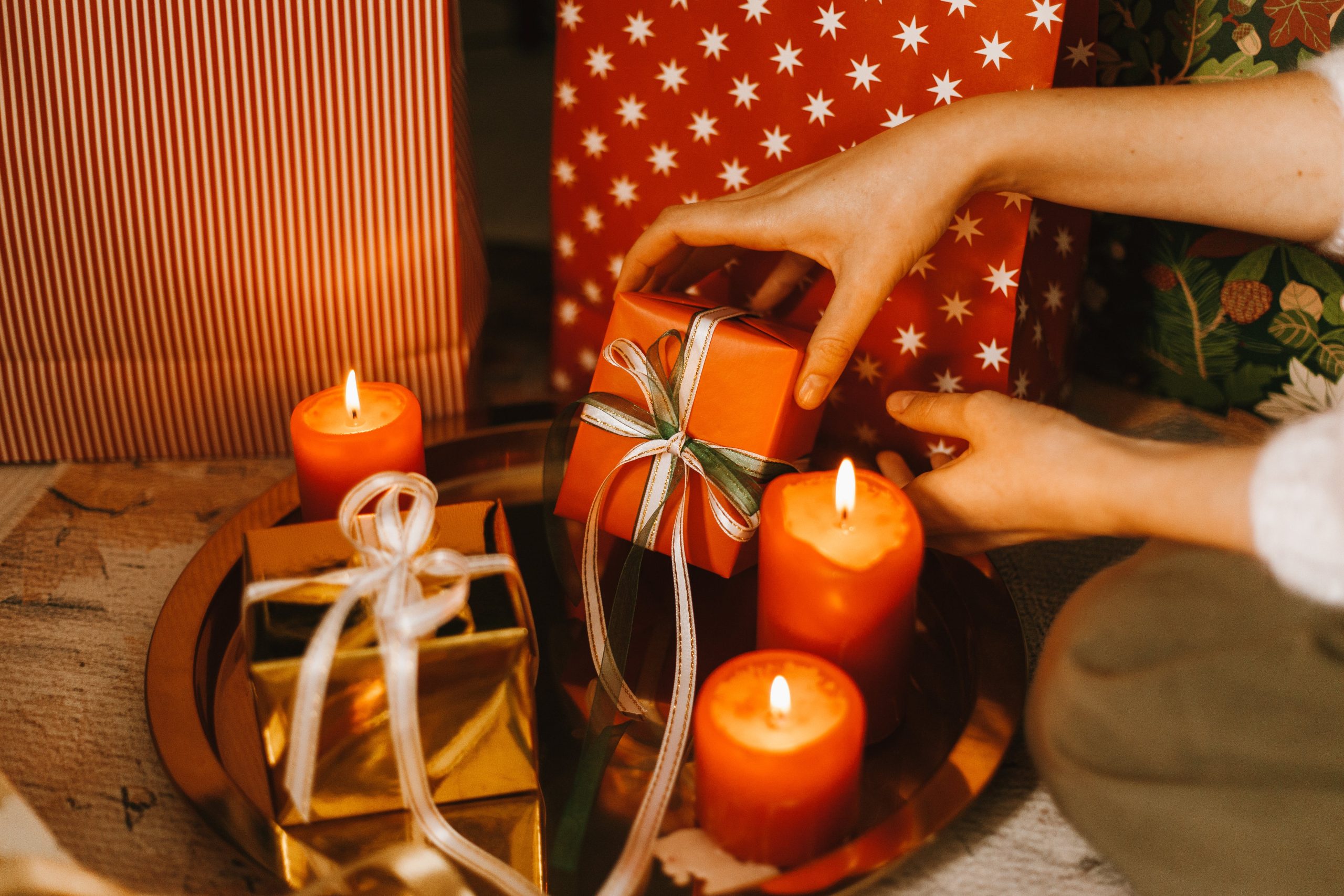 Vela iluminada junto a un regalo, simbolizando la conexión emocional y el bienestar en la psicología positiva durante las festividades.