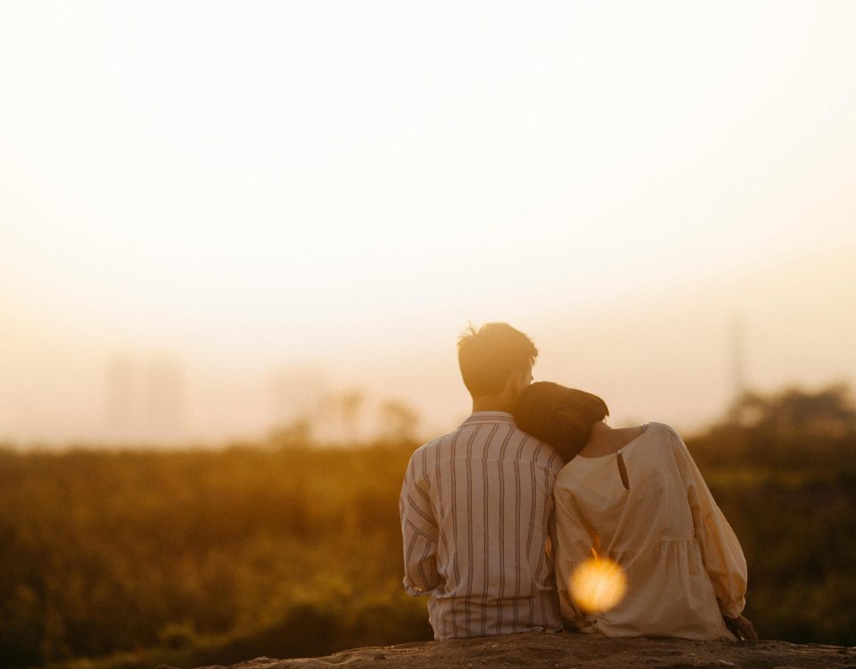 construir pareja abrazados con el sol de fondo