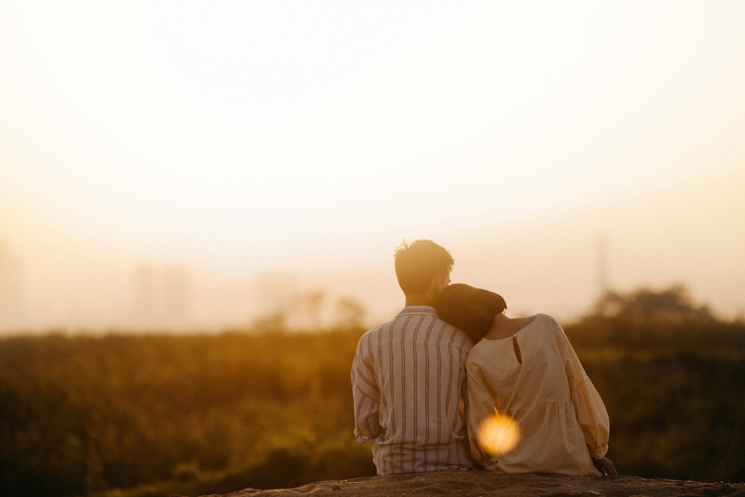 construir pareja abrazados con el sol de fondo