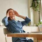 la somatización en dolor de cabeza de mujer trabajando.